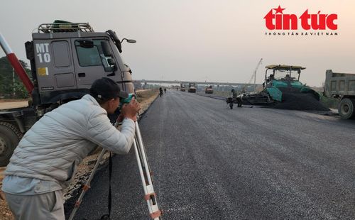 Kỹ sư đo đạc cốt mặt đường, đảm bảo lớp bê tông nhựa nóng thảm đúng thiết kế kỹ thuật.