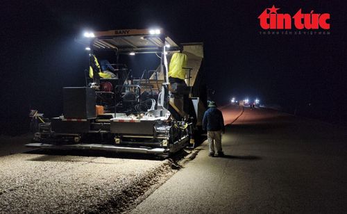 Công nhân thảm bê tông nhựa nóng trong đêm.