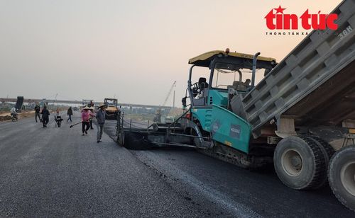 Các nhà thầu thảm bê tông nhựa nóng cuốn chiếu mặt đường cao tốc Mai Sơn - QL45 ở những vị trí đã dỡ tải, thi công xong móng, nền đường.