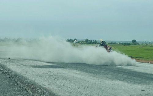 Công đoạn làm sạch mặt đường để thảm nhựa đang được gấp rút thi công - Ảnh: X.A