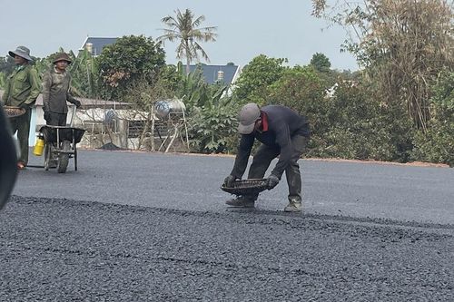 Công nhân trải thảm nhựa tại dự án - Ảnh: Hoàng Anh
