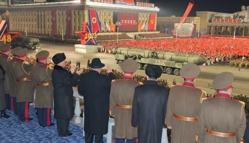 Ông Kim Jong-un và các quan chức Triều Tiên xem tên lửa ICBM mới diễu qua lễ đài (Ảnh: QQ).