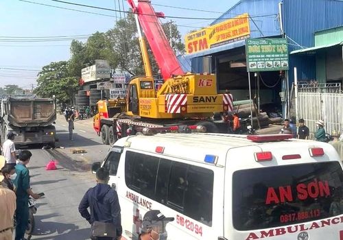 Lực lượng chức năng điều xe nâng để đưa thi thể nạn nhân ra khỏi bánh xe ben