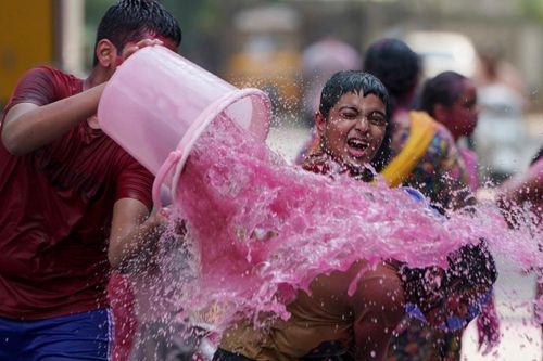 Những đứa trẻ vui vẻ tưới nước màu vào nhau trong lễ hội Holi ở Hyderabad. (Nguồn: AP)