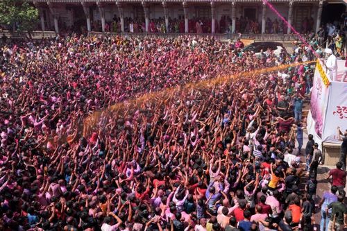 Các tín đồ đạo Hindu reo hò khi bột màu và nước được tưới lên người tại lễ hội Holi ở đền thờ Kalupur Swaminarayan ở Ahmedabad. (Nguồn: AP)