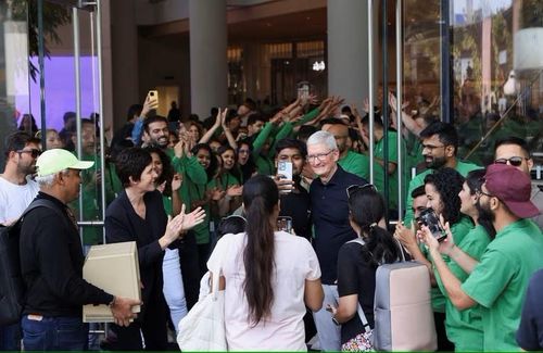 Người hâm mộ chụp hình với ông Tim Cook tại ngày khai trương cửa hàng. Ảnh: Reuters