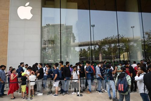 Khách hàng chờ đợi bên ngoài cửa hàng bán lẻ đầu tiên của Apple tại Mumbai, Ấn Độ, ngày 18/4/2023. Ảnh: AFP/ TTXVN