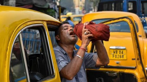 Một tài xế taxi uống nước giải khát giữa cái nắng buổi trưa ở Kolkata, Ấn Độ, vào ngày 18/4. (CNN)