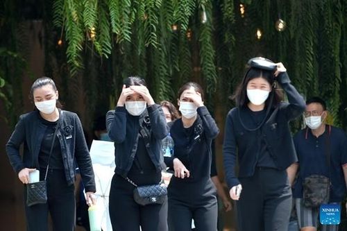 Người đi bộ cố che chắn dưới nắng nóng ở Bangkok (Thái Lan). Ảnh: Rachen Sageamsak/ Xinhua.
