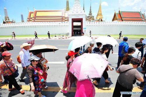 Khách du lịch tự bảo vệ mình khỏi ánh nắng gay gắt khi tham quan Cung điện Hoàng gia ở Bangkok, Thái Lan, ngày 19-4. Ảnh: THX