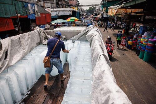  Một công nhân đang xử lý khối đá lạnh trong đợt nắng nóng ở Bangkok vào ngày 27/4. Ảnh: Bloomberg. 