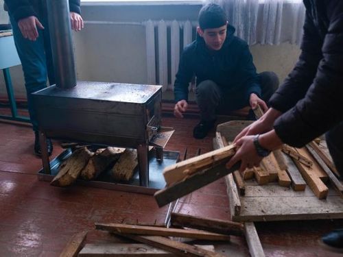 Các em học sinh ở Nagorno-Karabakh đốt củi để sưởi ấm lớp học