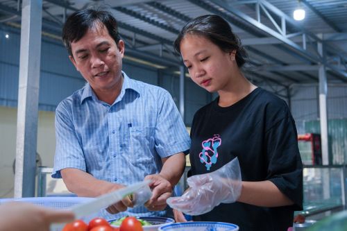 Trò vừa tham gia hỗ trợ vừa học hỏi thêm tại bếp ăn trường.
