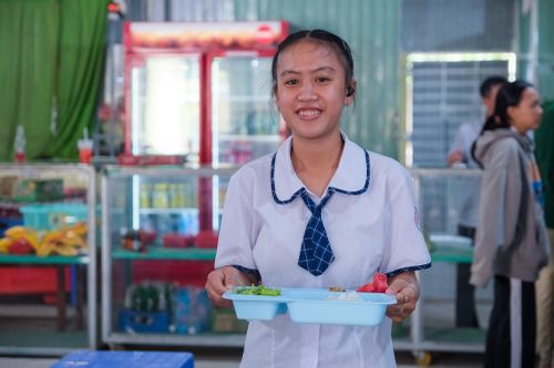 Anh Thư vui tươi nhận phần cơm của mình.