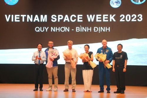 Ông Phạm Anh Tuấn - Chủ tịch UBND tỉnh Bình Định (bìa trái) tặng hoa cho cựu phi hành gia Michael Baker cùng các thành viên trong đoàn.