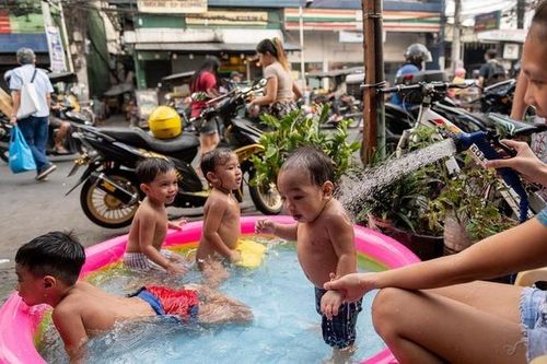 Trẻ em tắm giải nhiệt trong bể bơi bơm hơi ở Thủ đô Manila, Philippines