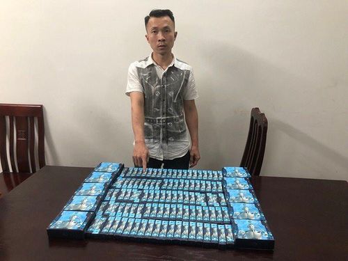 Đối tượng Trần Anh Dũng cùng tang vật 100 sản phẩm thuốc lá điện tử có chứa chất ma túy MDMB-4en-PINACA.