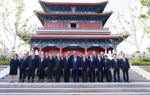 Thủ tướng Phạm Minh Chính và Bí thư Tỉnh ủy Hà Bắc Nghê Nhạc Phong cùng thành viên đoàn chụp ảnh chung tại Định An Các, Khu mới Hùng An. (Ảnh: Dương Giang/TTXVN)
