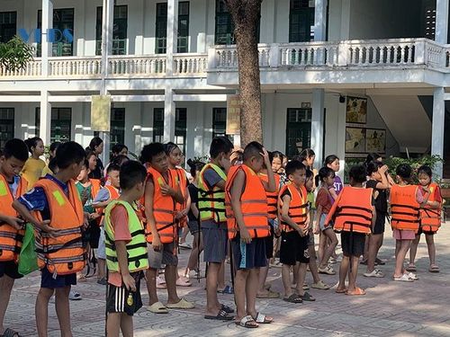 Học sinh Trường Tiểu học Luận Thành học cách mặc áo phao bơi. Ảnh: Vi An