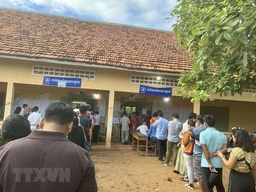 Cử tri Campuchia xếp hàng, chờ đến giờ bỏ phiếu trước các phòng bầu cử trong khuôn viên Trường THPT Chea Sim Chroy Changvar, quận Chroy Changvar, thủ đô Phnom Penh. (Ảnh: Huỳnh Thảo/TTXVN)