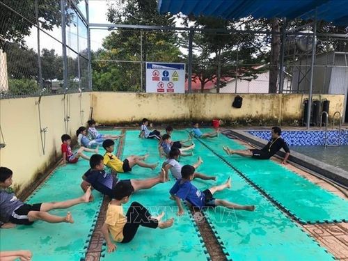 Giáo viên thể dục dạy bơi cho các em học sinh. Ảnh: TTXVN phát
