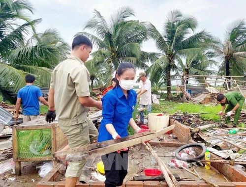 Lực lượng dân quân, đoàn thanh niên tham gia giúp người dân huyện U Minh khắc phục thiệt hại do dông lốc gây ra vào rạng sáng ngày 30/7. Ảnh: TTXVN phát