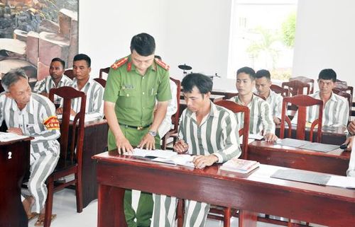 Đại úy Ngô Sinh Tồn, cán bộ Đội Giáo dục - Hồ sơ Trại giam Xuân Phước hướng dẫn phạm nhân tập viết và làm toán.
