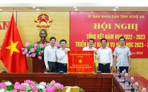 Phó Chủ tịch UBND tỉnh Nghệ An Bùi Đình Long trao Cờ thi đua của Chính phủ cho Sở GD&ĐT Nghệ An.