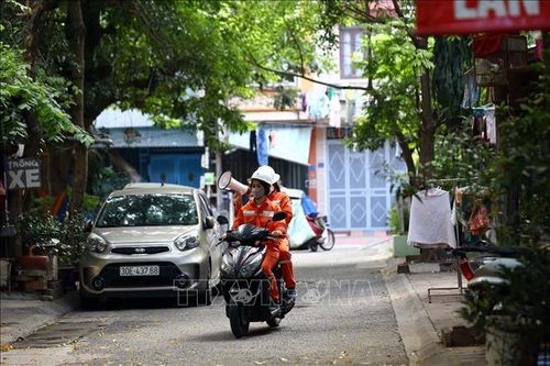 Tổ tuyên truyền lưu động được EVN Hà Nội triển khai đến các ngõ, phố, kêu gọi người dân tiết kiệm điện. Ảnh: TTXVN.