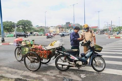 Một chiếc xe máy kéo theo xe ba gác chở đầy trái cây, chạy nghênh ngang trên đường bị Đội CSGT Chợ Lớn xử phạt