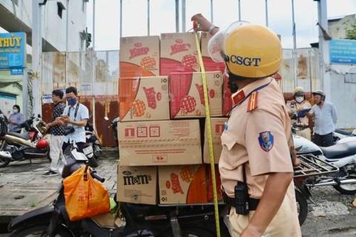 Cán bộ Đội CSGT Chợ Lớn tiến hành đo kích thước hàng hóa, xác định lỗi vi phạm