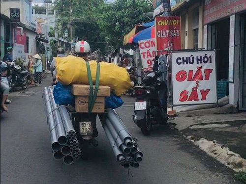 Người đàn ông chở theo 2 cuộn vải cồng kềnh lưu thông trên đường Tô Ký (Q12)