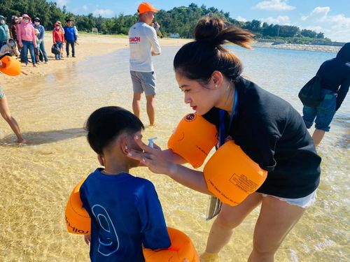 Ttrẻ học bơi được trải nghiệm sản phẩm bình xịt chống thấm nước, bảo vệ cho tai.