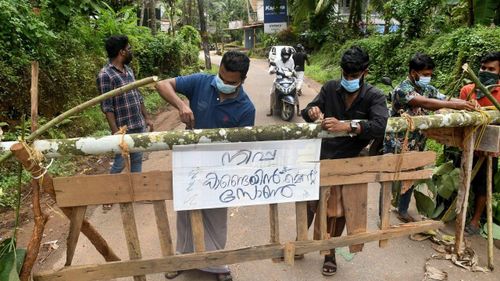 Người dân treo tấm biển ghi "Khu vực cách ly virus Nipah" ở quận Kozhikode, bang Kerala, Ấn Độ, ngày 13 tháng 9. (Ảnh: Reuters)