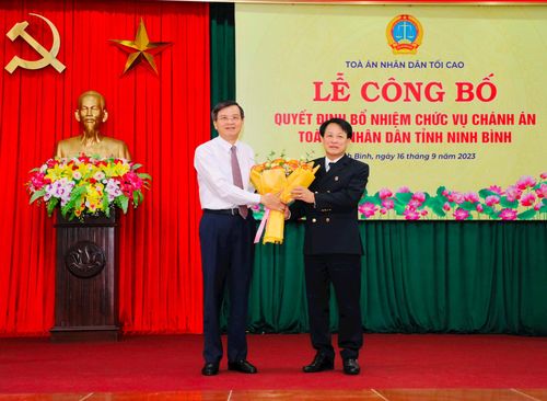 Đồng chí Đoàn Minh Huấn, Ủy viên Trung ương Đảng, Bí thư Tỉnh ủy Ninh Bình tặng hoa chúc mừng đồng chí Nguyễn Xuân Sơn, tân Chánh án TAND tỉnh Ninh Bình.