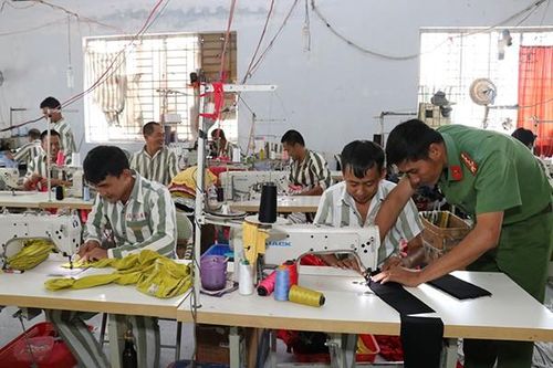 Cán bộ Công an hướng dẫn nghề may cho phạm nhân. (Nguồn: baocongan)