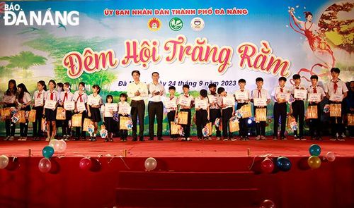 Phó Chủ tịch UBND thành phố Trần Chí Cường (thứ 10, từ trái sang) tặng học bổng cho học sinh nghèo vượt khó. Ảnh: X.D