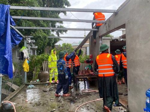 Công an phường Thuận An và lực lượng BĐBP tỉnh Thừa Thiên Huế giúp dân lợp lại mái nhà.