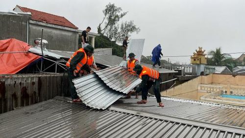 Hỗ trợ người dân lợp lại mái nhà bị lốc xoáy thổi tốc mái.