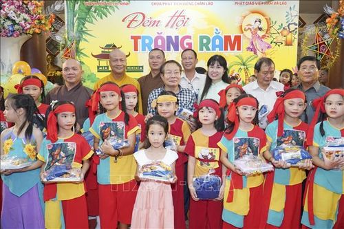 Ban tổ chức chụp ảnh chung với một nhóm các cháu thiếu niên nhi đồng được nhận học bổng. Ảnh: Đỗ Bá Thành/PV TTXVN tại Lào