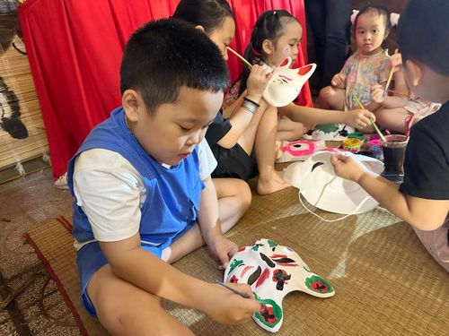 Các bạn nhỏ chăm chú tô vẽ mặt nạ Trung thu. 