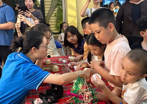 Các em nhỏ được hướng dẫn làm đèn ông sao. 