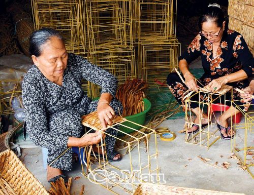 Bà Nguyễn Thị Thắm (bìa trái), 73 tuổi, ở ấp Nguyễn Huế, xã Tân Bằng, huyện Thới Bình, miệt mài giữ nghề đan đát, truyền lại cho các con, cháu cùng làm để tăng thu nhập.