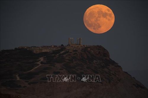 Hiện tượng siêu trăng nhìn từ Cape Sounion, Hy Lạp tối 30/8. Ảnh: THX/TTXVN