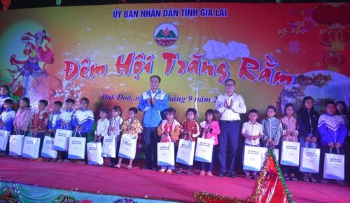 Đại diện lãnh đạo huyện Đak Đoa trao quà của UBND tỉnh cho trẻ em nghèo. Ảnh: Đinh Yến 