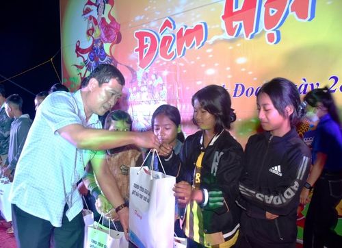 Ông Phạm Trần Anh-Phó Giám đốc Sở Lao động-Thương binh và Xã hội trao phần quà của UBND tỉnh cho trẻ em nghèo. Ảnh: Đinh Yến