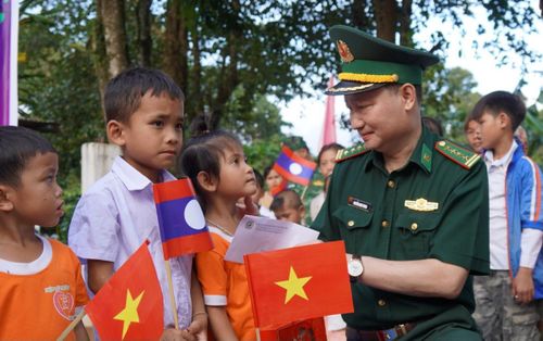 Đại tá Nguyễn Nam Trung trao học bổng cho các học sinh Lào và Việt Nam. Ảnh: Trúc Hà