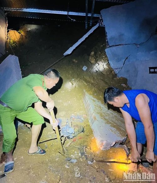 Lực lượng cứu hộ tìm kiếm nạn nhân bị tường đè do sạt đất tại xã Ngòi A, huyện Văn Yên.