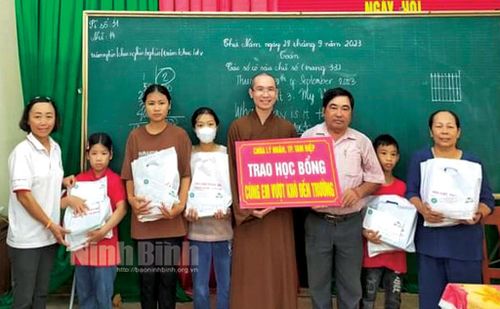 Đại diện Hội Chữ thập đỏ thành phố Tam Điệp và nhà hảo tâm tặng học bổng cho học sinh nghèo.