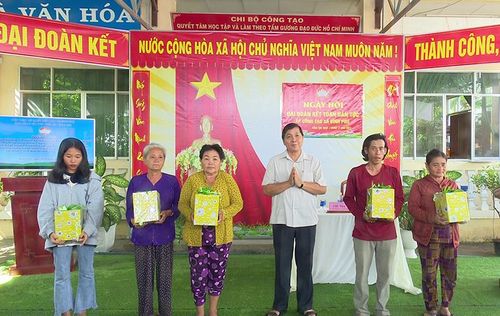 Trưởng Ban Dân vận Tỉnh ủy, Chủ tịch Ủy ban Mặt trận Tổ quốc Việt Nam tỉnh Lê Thành Công tặng quà cho 5 hộ gia đình tự nguyện xin trả lại sổ hộ nghèo (Ảnh: Thùy Dung)